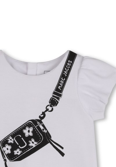T-shirt blanc à manches courtes bouffantes, avec un motif noir représentant un petit sac orné d'accents floraux et une bandoulière portant l'inscription "MARC JACOBS".