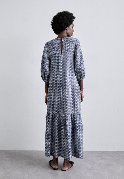 Rochie maxi cu imprimeu floral albastru și alb, având mâneci bufante, spate cu decupaj și tiv volanat. Fabricată dintr-un material ușor.