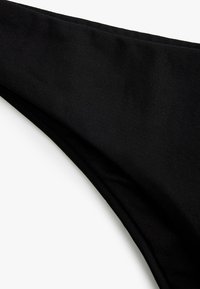 Tela negra con una textura suave y un brillo sutil, que presenta un borde curvado y un diseño minimalista. Sin patrones ni herrajes visibles.