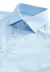 Chandail bleu clair à col, fabriqué dans un tissu lisse, présentant un devant à boutons, avec deux boutons visibles et un col structuré.