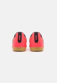 Zapatillas deportivas de color rosa brillante con acentos negros y un acabado texturizado. Presentan un diseño de perfil bajo y suela de goma. Logo "SALA" en el talón.