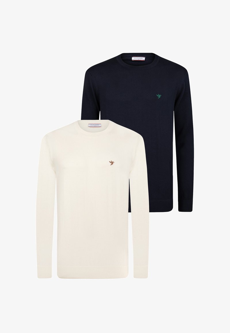 Twee crew neck sweaters tentoongesteld: de ene in crèmekleur met een klein bruin vogel logo, de andere in marineblauw met een groen logo. Beide hebben geribbelde manchetten.