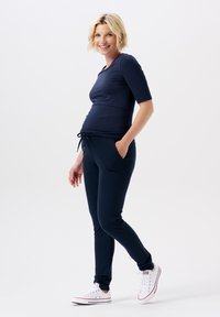 Navy maternity top with short sleeves and a rounded neckline, paired with matching joggers featuring a drawstring waist and side pockets.