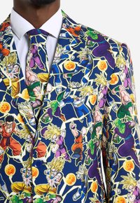 Bunter Anzug mit einem Muster aus Dragon Ball Figuren auf einem navyblauen Hintergrund. Das Material wirkt glatt und hat einen Knopfverschluss sowie eine passende Krawatte.