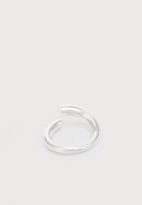 Anillo de plata con un diseño circular abierto, que presenta una textura suave y brillante, y un estilo minimalista. Destaca por su curva ininterrumpida.