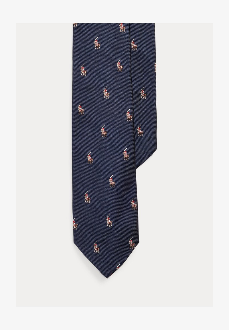 Navyblå slips med diagonalt räfflad textur, prydd med små röda och beigea ryttarmotiv jämnt fördelade över hela.