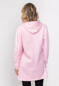 Różowa bluza z kapturem i długimi rękawami, wykonana z miękkiego materiału, o luźnym kroju i zaokrąglonym ściągaczu na dole.