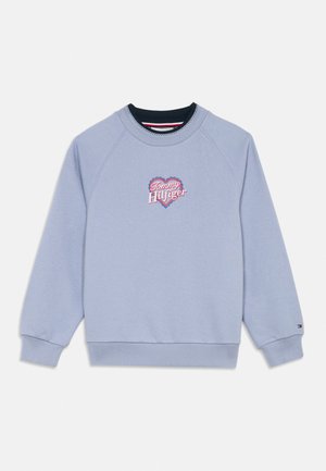 Világoskék környakú pulóver bordázott mandzsettákkal és szegéllyel, a mellrészen szív alakú "Tommy Hilfiger" hímzett logóval.