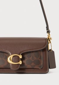 Brown leather shoulder bag with a textured darker brown patterned panel, gold hardware clasp, and a tag attached by a metal chain.