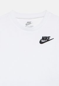 Λευκό βαμβακερό μπλουζάκι με μαύρο κεντημένο λογότυπο Nike στην αριστερή πλευρά του στήθους, με κλασικό σχέδιο  λαιμού τύπου crew neck.