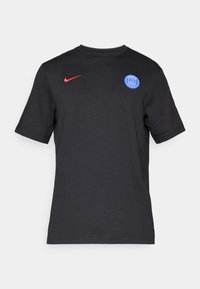Sort kortærmet T-shirt lavet af bomuld. Har et blåt Paris Saint-Germain-logo og et rødt Nike swoosh på venstre side. Enkel design med rund hals.