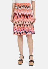 Gonna a zigzag multicolore nelle tonalità di rosa, arancione e nero. Lunghezza sopra il ginocchio con una vita elastica per il massimo comfort.