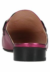 Roze leren platte schoen met een zwarte rand en een lage blokhak. Het interieur heeft een gladde beige voering en een zachte, iets gestructureerde oppervlakte.