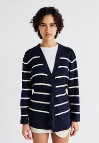 Cardigã listrado azul-marinho com linhas brancas, design envolvente, mangas longas e um cinto amarrado na cintura. Material de malha macia com um ajuste descontraído.