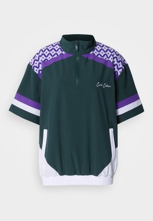 Pullover con mezza zip in verde scuro con dettagli viola e bianchi. Presenta spalle decorate e tasche laterali. Vita elasticizzata per una vestibilità regolabile.
