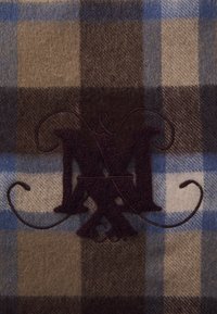 Ruud koosseis pruunide, beeži ja siniste toonidega, pehme tekstuuriga. Sellel on tume burgundi värvi broderi "M&Co" logo.