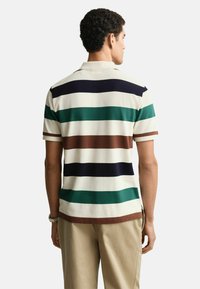 Gestreept poloshirt met verticale banden in marineblauw, groen, bruin en wit. Klassieke kraag en korte mouwen, gemaakt van een ademende stof.