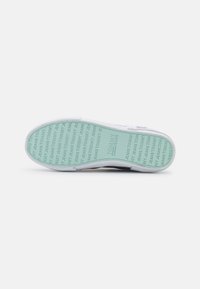 Białe sneakersy z miętową gumową podeszwą, z teksturowanym logo. Płaski, okrągły kształt noska oraz gładka cholewka z minimalnymi akcentami.