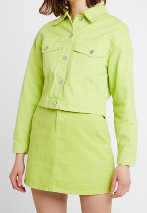 Giacca di jeans corta verde lime con due tasche sul petto, chiusura a bottone e gonna mini abbinata. Tessuto morbido, design casual.