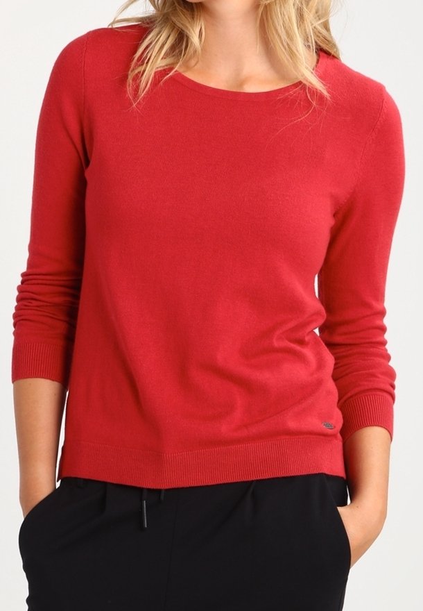 Pull en tricot rouge avec manches longues, col rond et poignets côtelés. Texture douce et coupe ajustée. Logo de marque discret près de l'ourlet.