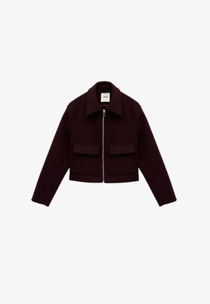 Bordeauxfarbene kurz geschnittene Jacke mit flachem Kragen, Reißverschluss und zwei Fronttaschen mit Klappen. Hergestellt aus einem dicken, strukturierten Material.