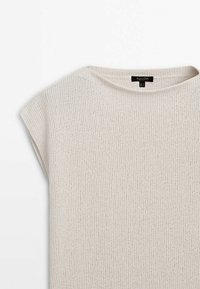 Pull sans manches tricoté beige clair avec un col rond, posé à plat sur un fond blanc.