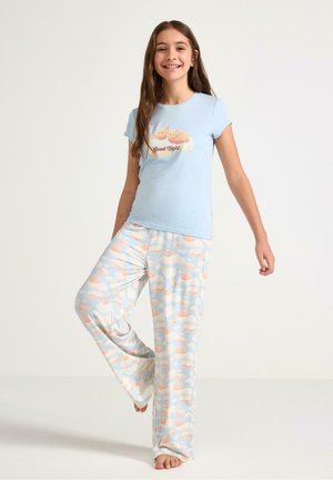 Lichtblauw pyjamaset met een kortärmelig shirt bedrukt met een wolk en de tekst "Goede Nacht". De broek is bedrukt met pastelkleurige wolken en lachende gezichten.