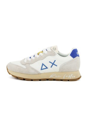 Chaussure de course blanche et beige avec des accents bleus, des détails en daim, des symboles triangulaires et en X, et le texte « Courez plus vite » sur la semelle.