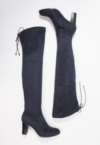 Botas azul marino hasta encima de la rodilla en suave ante, con punta redondeada, tacón alto y detalle de lazo ajustable en la parte superior para un mejor ajuste.