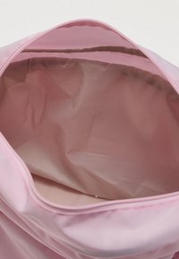 Ροζ υφασμάτινη τσάντα με ευρύ άνοιγμα και λείο, υφασμένο εσωτερικό. Διαθέτει ραμμένες ραφές και ελαφρύ σχεδιασμό.