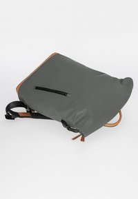 Grau wasserdichter Rucksack mit braunem Ledereinsatz, Reißverschlussfach und verstellbaren Riemen. Verfügt über eine quadratische Form und eine glatte Textur.
