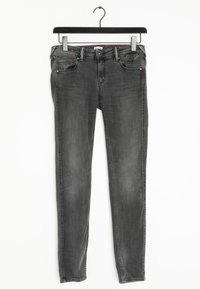 Jeans slim-fit negros con un lavado desgastado, diseño clásico de cinco bolsillos y cierre de botón metálico. Hechos de denim con detalles de costura sutiles.