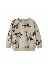 Sweatshirt beige clair orné d'imprimés de dinosaures noirs, incluant un stégosaure et un brontosaure, avec un col et des poignets côtelés.