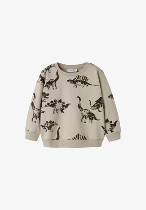 Ljusbeige sweatshirt med svarta dinosauriemönster, inklusive stegosaurus och brontosaurus, med ribbade krage och ärmslut.