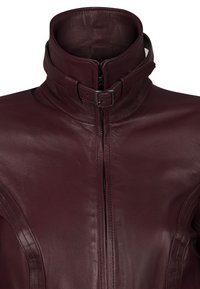 Burgundy läderjacka med hög krage, med dragkedjestängning och detaljer rund halsen med bälte. Slät textur och skräddarsydd passform.