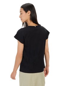 Zwarte t-shirt met korte mouwen, ontspannen pasvorm en een ronde halslijn. Gladde katoenen stof met een subtiele achternaad detail.