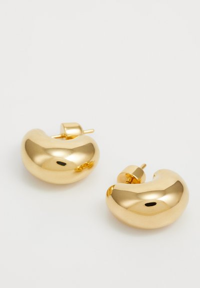 Guldtonede metal hoops med et glat, afrundet design, der har en poleret overflade og en stud-baggrund for sikker bæring.