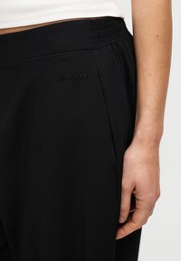 Μαύρα joggers με απαλή υφή, που διαθέτουν ελαστική μέση, πλαϊνές τσέπες και διακριτικό λογότυπο Calvin Klein στο μπροστινό μέρος.