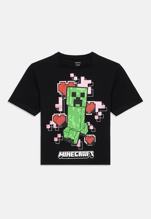 Maglietta nera in cotone con personaggio verde di Minecraft pixelato, cuori rosa e design a blocchi, con la scritta "Minecraft" sotto.