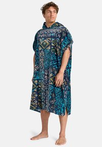 Blå og turkise mønstrede poncho med hætte, prydet med geometriske designs og en lomme, lavet af blødt og absorberende materiale.