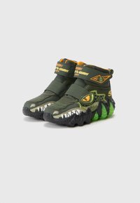 Tmavě zelené vysoké dětské tenisky s designem dinosaura, oranžovými akcenty, suchými zipy a zelenými detaily ve tvaru drápu na podrážkách.