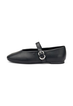 Zapato plano de cuero negro con punta redondeada, correa en el tobillo y detalle de hebilla. Textura suave y diseño minimalista. Suela de perfil bajo.