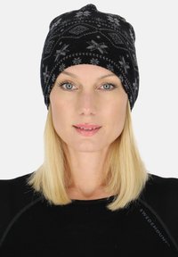 Black knitted beanie with gray snowflake pattern and geometric designs. Soft texture, rounded shape, and slight slouch at the top.