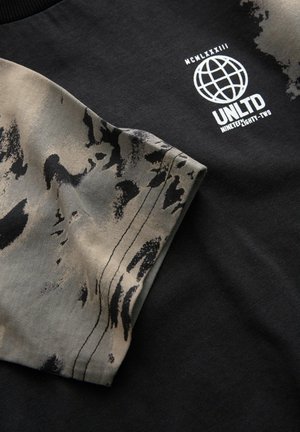 Black sweatshirt featuring a graphic half-sleeve in beige with abstract gray patterns. Includes white logo and text detailing.