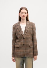 Blazer à carreaux marron avec une coupe ajustée, fermeture à un bouton et deux poches à l'avant. Fabriqué en tissu texturé avec un motif classique.