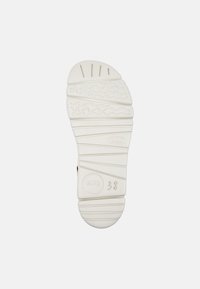 White rubber shoe sole with textured grip patterns, raised wave-like details, and embossed logo, size 38. Smooth finish with slight sheen.