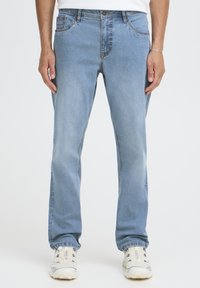 Lyseblå denimjeans med rette ben, fem lommer og en svak falming. Har knapp- og glidelåslukking ved livet.