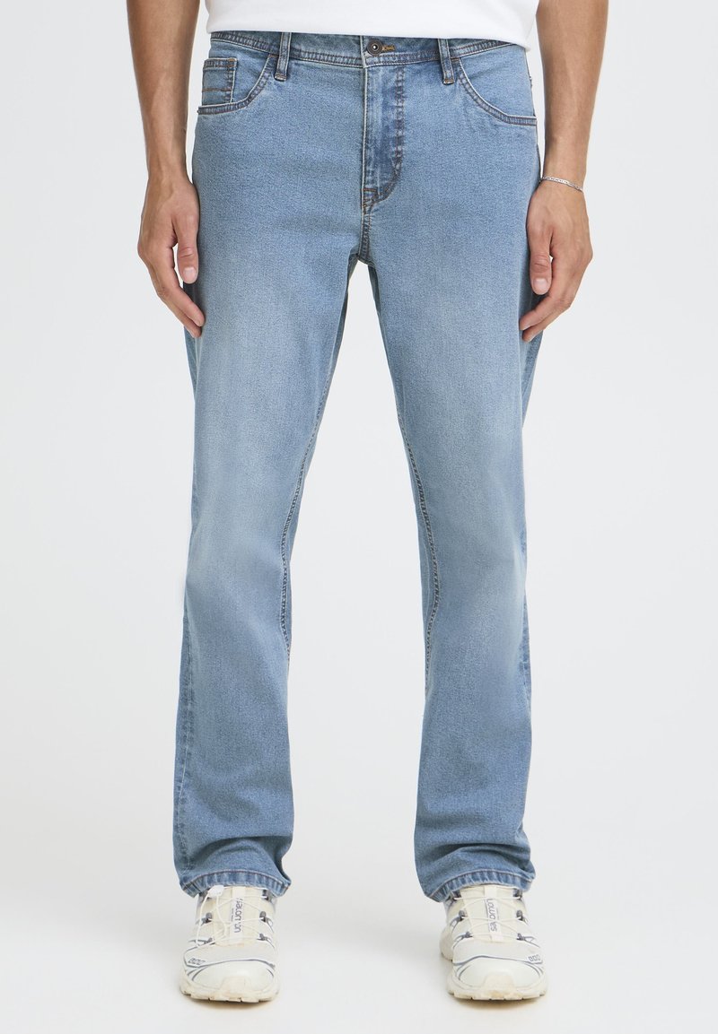 Lyseblå denimjeans med rette ben, fem lommer og en svak falming. Har knapp- og glidelåslukking ved livet.