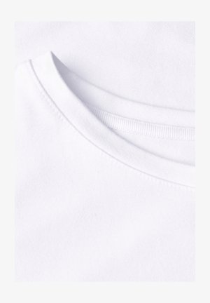 Primo piano di una T-shirt bianca con scollo rotondo che mostra i dettagli delle cuciture e la trama del tessuto.