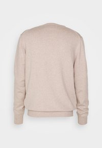 Beżowy sweter o delikatnej fakturze, z okrągłym dekoltem, długimi rękawami i luźnym krojem. Dolna krawędź i mankiety są wykończone ściągaczem dla lepszego dopasowania.